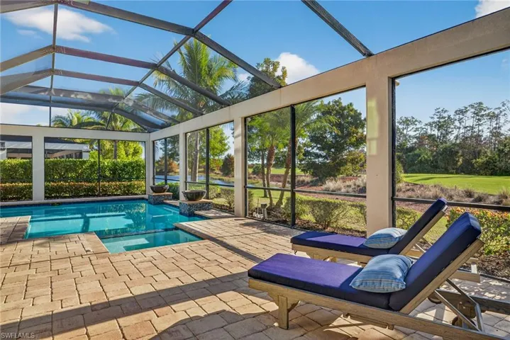 View of pool with a sunroom, a lanai, and a pool with connected hot tub