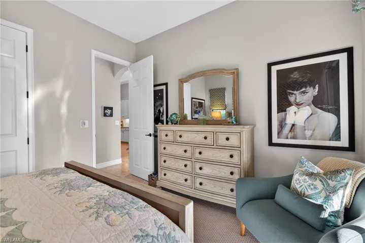 Bedroom featuring light colored carpet and arched walkways