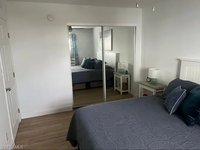Bedroom with a closet, baseboards, and wood finished floors