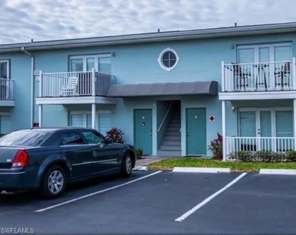 View of building exterior with uncovered parking