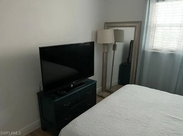 Bedroom featuring wood finished floors and baseboards
