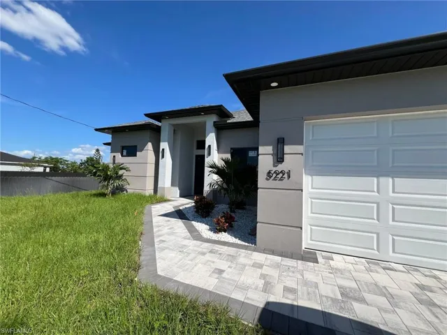 View of front of home featuring a front yard and a garage
