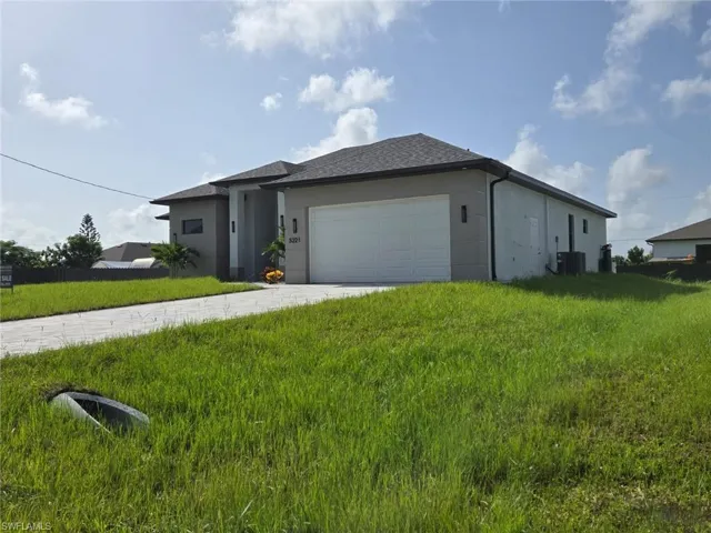 View of front facade with a garage, central AC, and a front yard