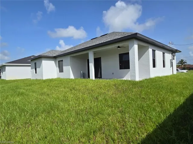 Back of house with a lawn