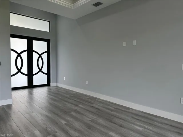 Foyer with dark hardwood / wood-style flooring and ornamental molding