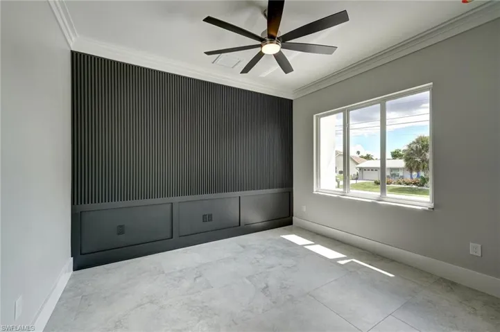 Spare room featuring ornamental molding and a ceiling fan
