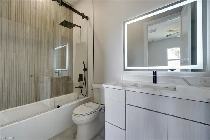 Bathroom 3with combined bath / shower with glass door and vanity