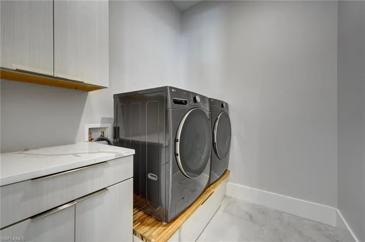 Laundry area featuring independent washer and dryer and cabinet space