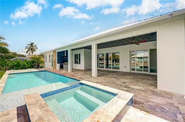View of pool featuring a ceiling fan, a patio, and a pool with connected hot tub