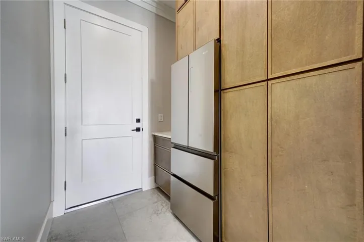 Kitchen featuring freestanding refrigerator, modern cabinets, and light tile patterned floors