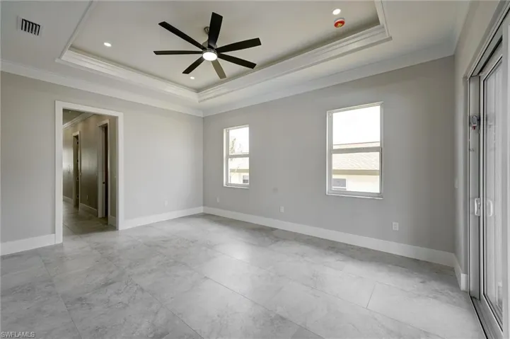 Unfurnished room with a tray ceiling, crown molding, a ceiling fan, and recessed lighting