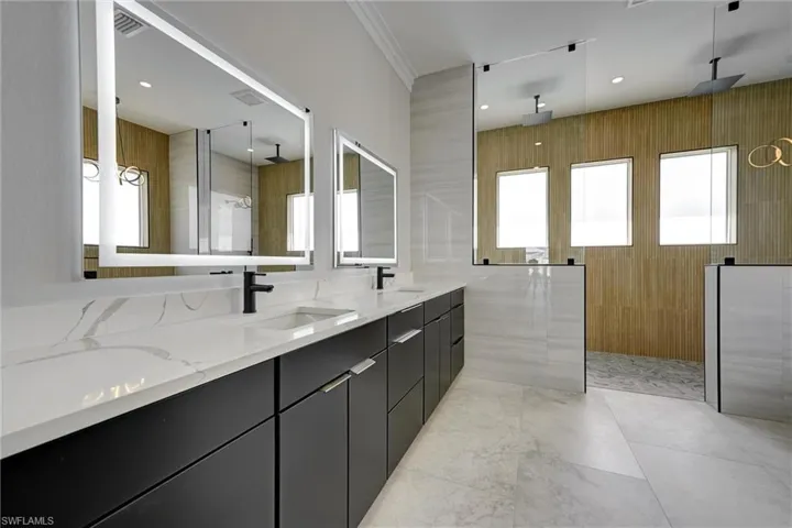 Full bathroom with double vanity, a walk in shower, recessed lighting, and ornamental molding