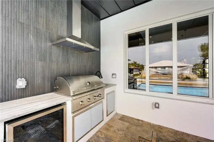 View of patio with wine cooler and an outdoor kitchen