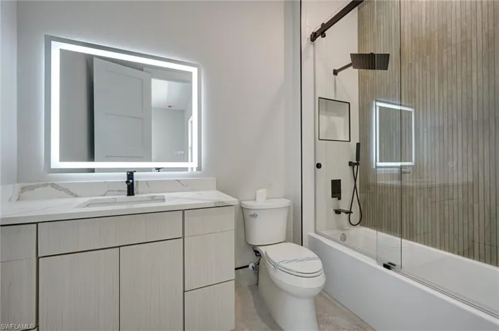 Full bathroom 2with shower / bath combination with glass door and vanity