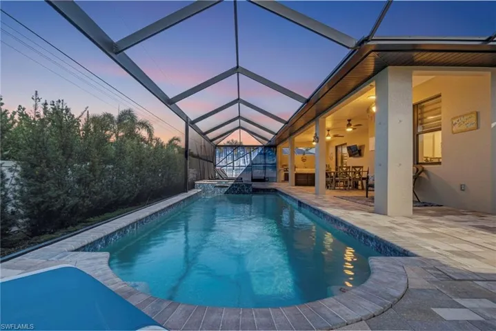 Integrated pool / spa featuring a sunroom, glass enclosure, a patio, and outdoor dining area