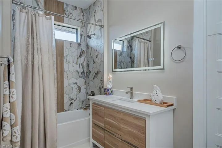 Full bath featuring shower / bath combo and vanity