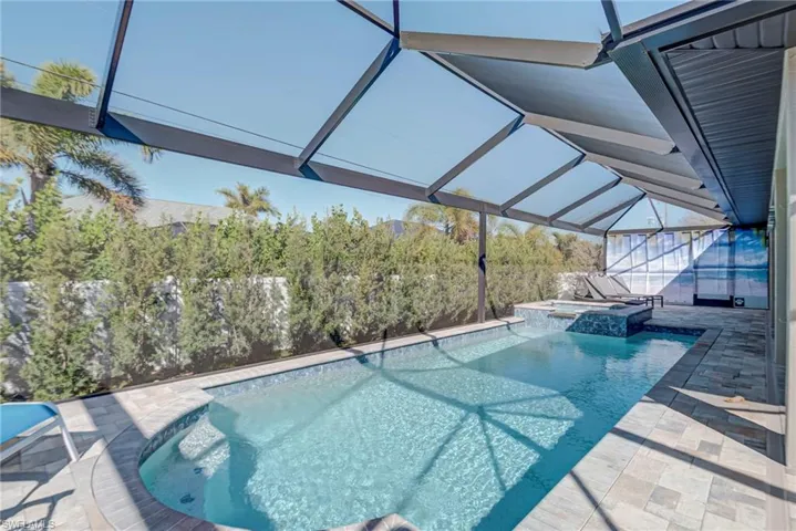 Combined pool / hot tub with a lanai, a patio area, and a sunroom