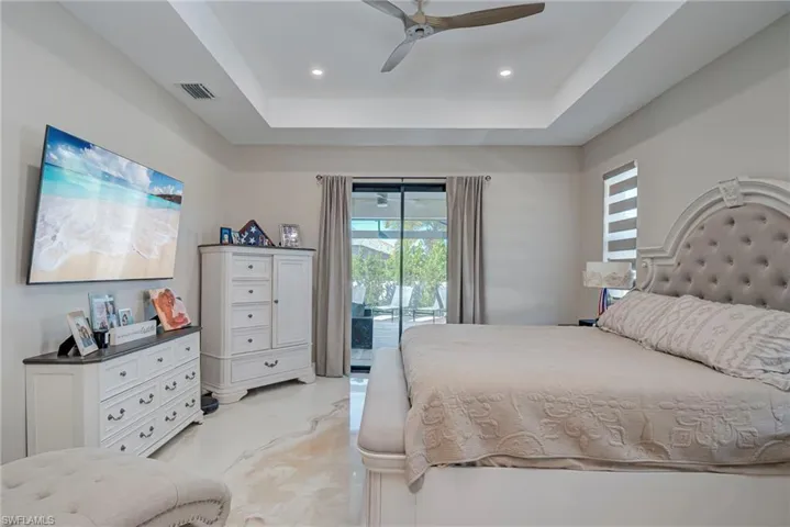 Bedroom featuring a tray ceiling, access to outside, ceiling fan, and recessed lighting