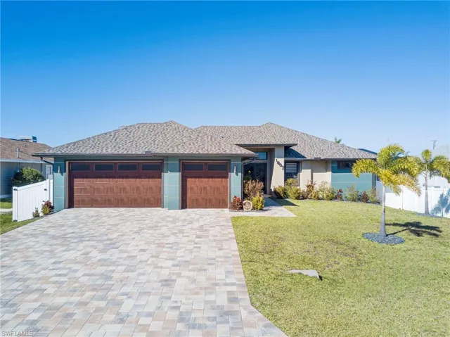 Prairie-style home featuring decorative driveway, stucco siding, and an attached garage