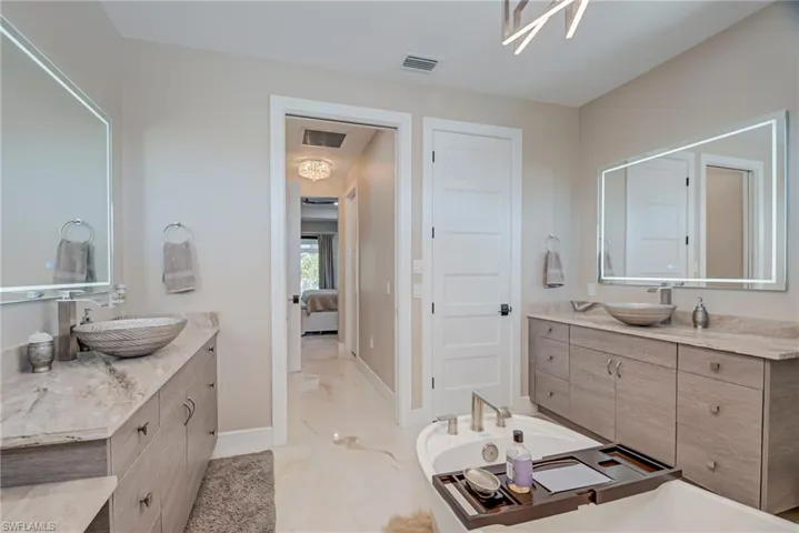 Full bathroom with vanity, ensuite bath, and a tub to relax in