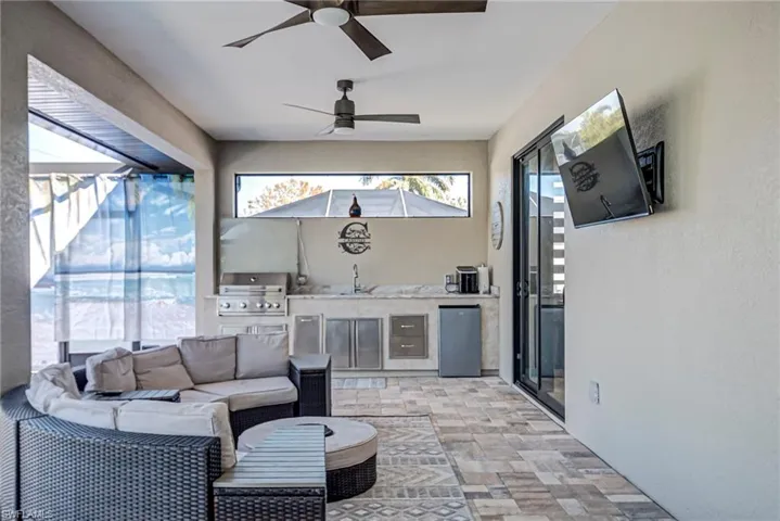 View of patio / terrace featuring an outdoor kitchen and area to lounge, a ceiling fan, and a sunroom