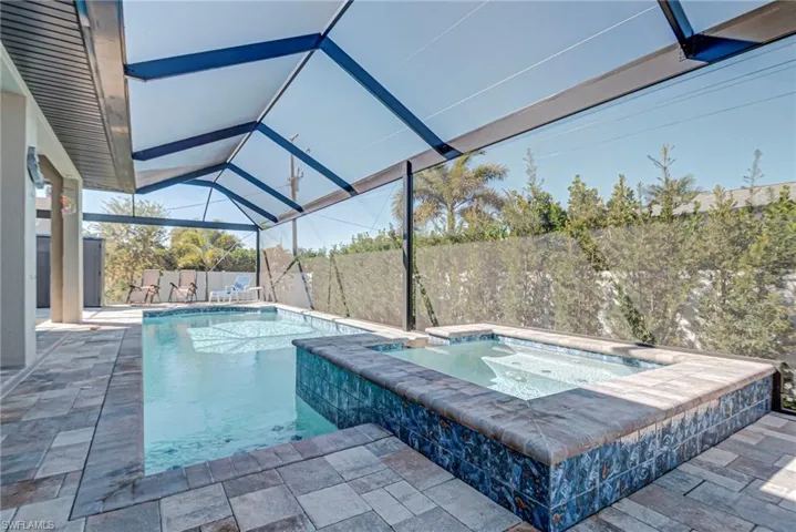 Integrated pool / spa featuring a sunroom, a patio, a fenced backyard, and glass enclosure