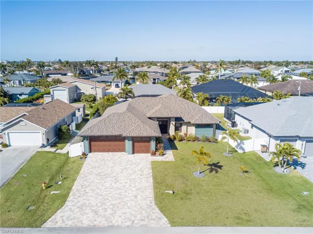 View of front of property with an attached garage, decorative driveway, and a residential view