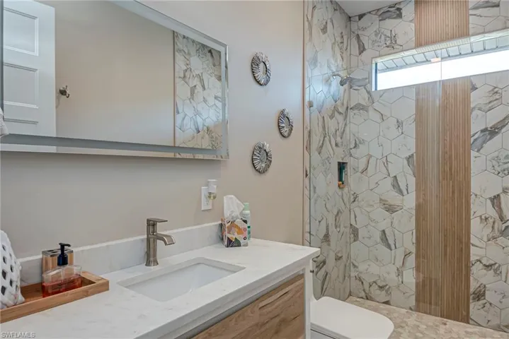 Bathroom with a marble finish shower and vanity