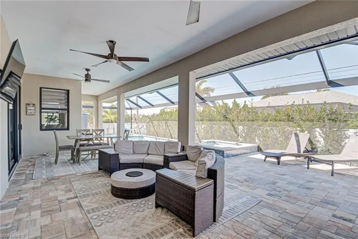 View of patio / terrace with outdoor lounge area, a sunroom, glass enclosure, an outdoor pool, and an in-ground hot tub