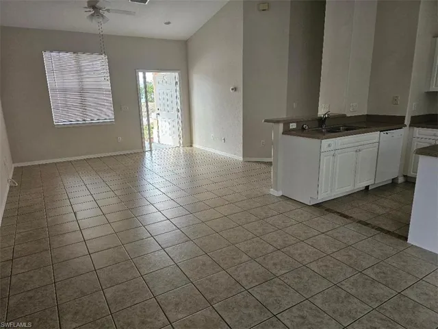 Kitchen featuring white cabinets, a peninsula, ceiling fan, and light tile patterned flooring