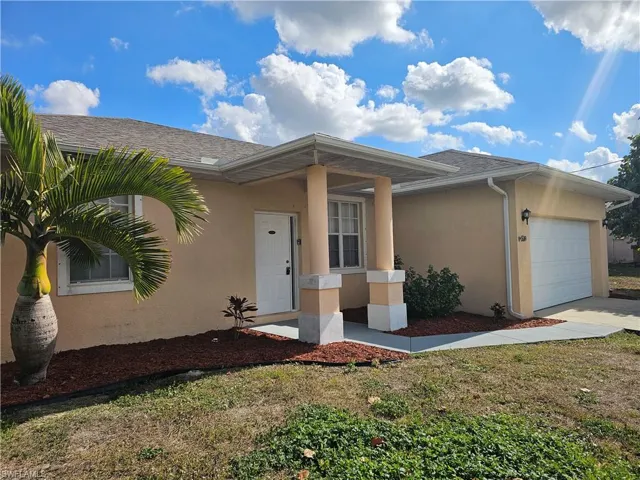 Single story home featuring stucco siding, a garage, a front lawn, and concrete driveway