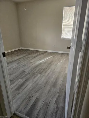 Empty room with light wood-type flooring and baseboards