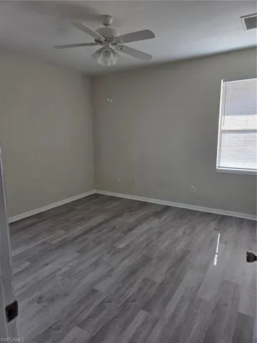 Empty room with wood finished floors and ceiling fan