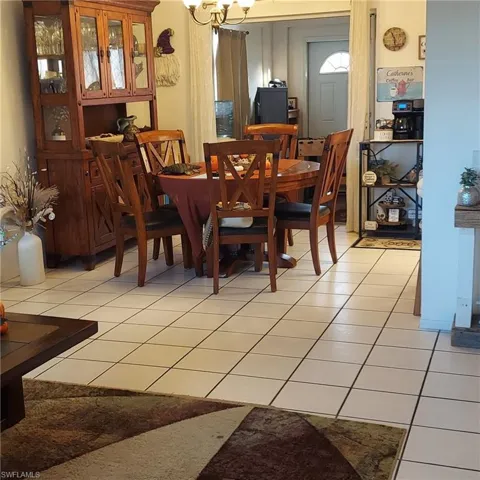 Dining room with light tile patterned floors and a chandelier
