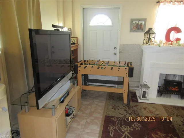Entrance foyer featuring a lit fireplace