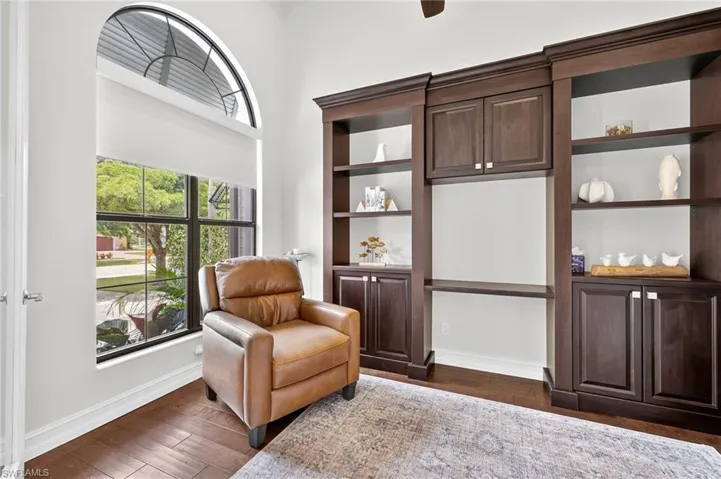 Sitting room featuring dark wood-style flooring and baseboards