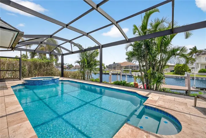 View of pool featuring a pool with connected hot tub, a water view, a lanai, and a patio