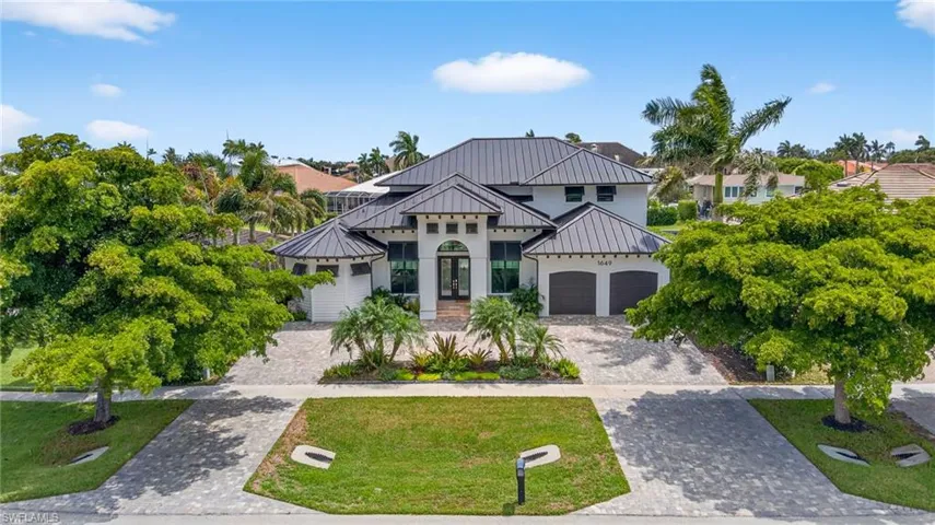 View of front of home featuring french doors, decorative driveway, a standing seam roof, a metal roof, and a front lawn