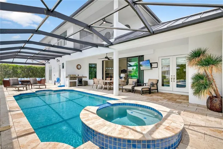 View of swimming pool with french doors, an outdoor hangout area, a pool with connected hot tub, area for grilling, and a patio
