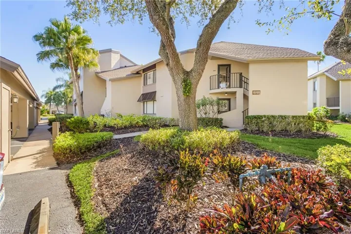 View of front of house featuring a balcony, stucco siding, and a shingled roof