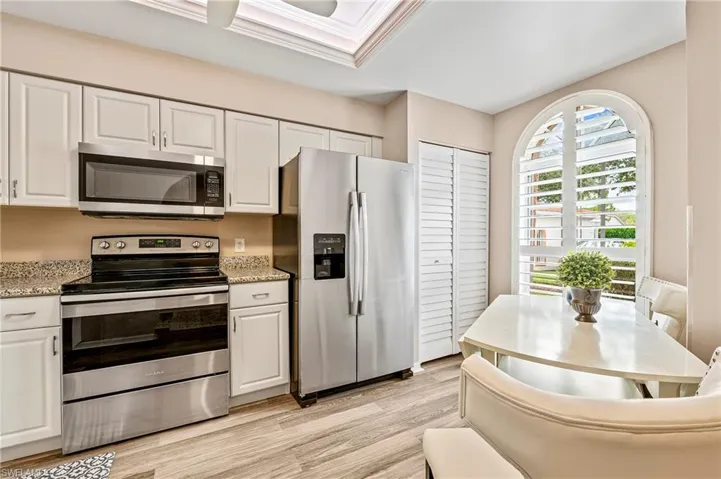 Kitchen featuring appliances with stainless steel finishes and white cabinetry