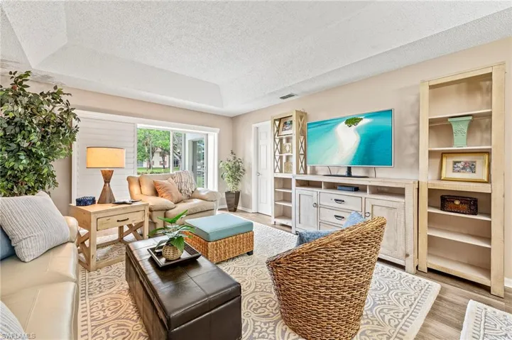 Living room featuring a tray ceiling and a textured ceiling