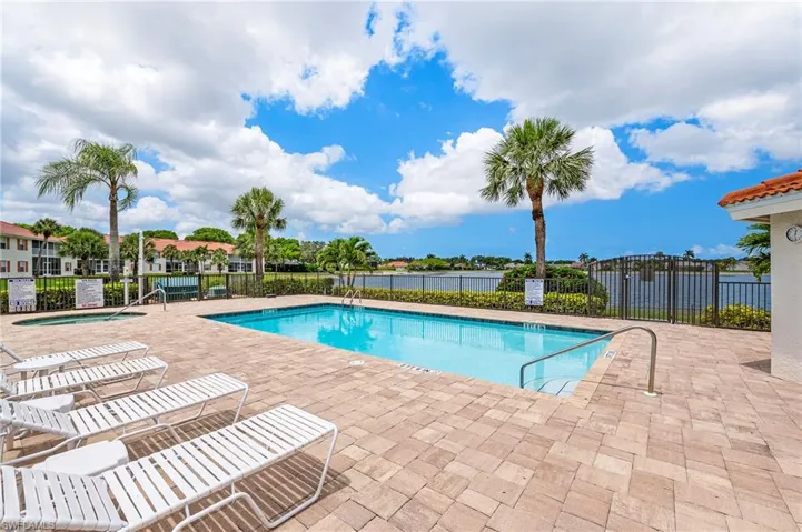 Community pool featuring a patio, a community hot tub, and a water view