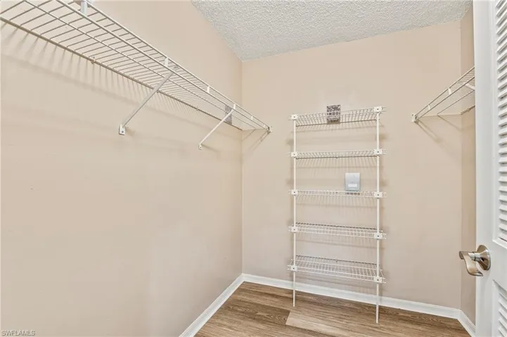 Walk in closet with light wood-type flooring