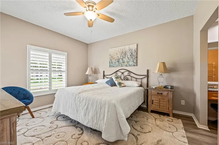 Bedroom featuring a textured ceiling, wood finished floors, and ceiling fan