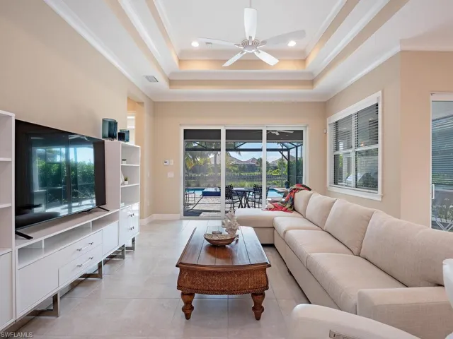 Living Room with double tray ceilings and impact glass sliders open fully (slide into wall).