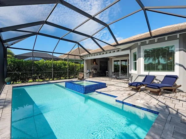 View of pool and spa looking toward the house with summer kitchen and outdoor dining area.