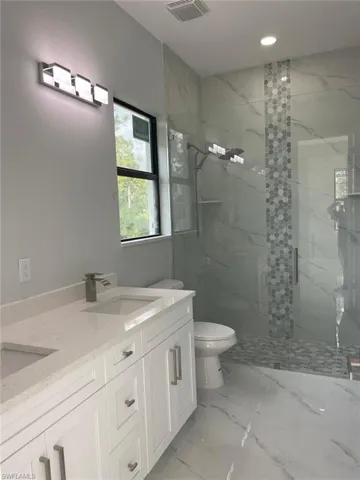 Bathroom featuring vanity, toilet, and walk in shower