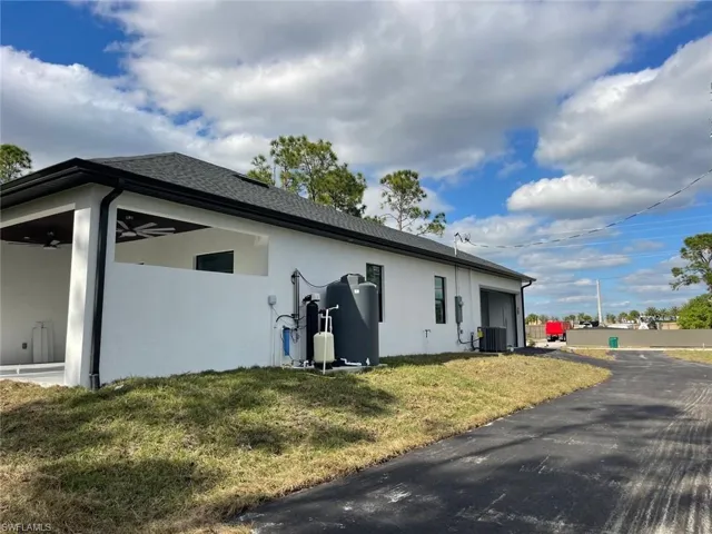 View of home's exterior with a lawn and cooling unit