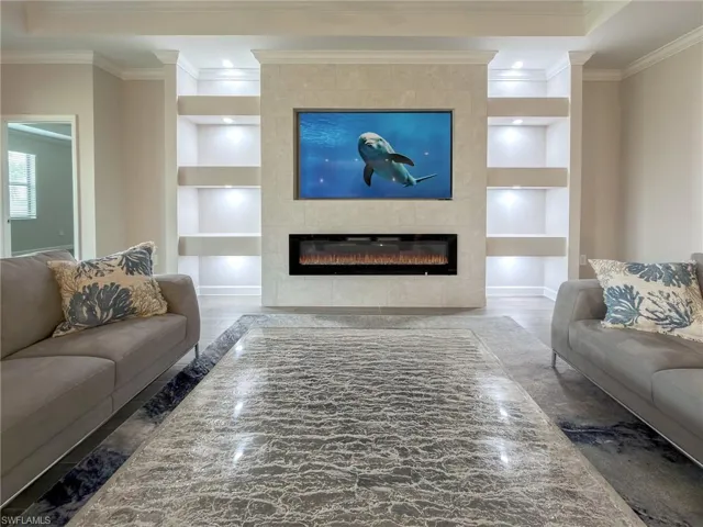Living area featuring built in features, a fireplace, ornamental molding, wood finished floors, and recessed lighting